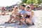 Shallow focus shot of a group of Caucasian friends having fun on a sandy beach