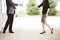 Shallow focus shot of a male and a female reaching to each other to shake hands by a building