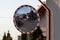 Shallow focus shot of a wide-angle driveway road mirror with a blurred background