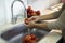 Shallow focus shot of a woman washing tomatoes