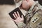 Shallow focus shot of a young soldier praying while holding the bible