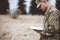 Shallow focus shot of a young soldier reading a bible in a field