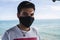 Shallow focus of a young male with a facemask at the Chiclana beach, Cadiz, Spain