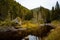 Shallow lake surrounded by lush dense green mountain forests