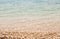 Shallow pale blue sea on shingle beach