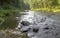 Shallow picturesque rocky fast river flows in the taiga