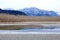 Shallow Winter Riverbed and Mountains