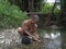 Shaman cleaning chicken viscera in a river