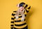 Shame. Close up young woman covering face with hands, model wearing woolen cap and sweater, isolated on yellow background. Ashamed