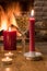 Shampagne glass, christmas candles against cozy firepace