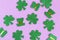 Shamrocks and leprechaun hats pattern on purple background. Minimal concept.