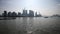 Shanghai bund viewed from ferry ship, skyscrapers and landmarks with blue sky background, cargo ships sailing on Huangpu river