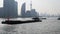 Shanghai bund viewed from ferry ship, skyscrapers and landmarks with blue sky background, cargo ships sailing on Huangpu river