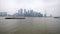 Shanghai, China - Feb. 21, 2019: cargo ships sailing in Huangpu river with Shanghai Bund skyscraper landscape and overcast sky