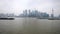 Shanghai, China - Feb. 21, 2019: cargo ships sailing in Huangpu river with Shanghai Bund skyscraper landscape and overcast sky