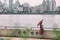 Shanghai city bund river Asian woman walking under rain with umbrella on China Asia vacation. Elegant chinese tourist