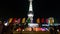 Shanghai Oriental Pearl Tower with flying flg at night,moving people silhouette.