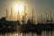 Shape of boat masts and cranes at sunset in Toulon port, France.