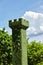 In the shape of a castle tower topiary green trees hedge in ornamental garden with blue sky background