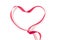 The shape of a heart is made of a red satin ribbon and is on a white background. Valentine`s Day minimalist layout.