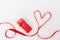 Shape of heart from red ribbon and red gift box on white wood background. Happy Saint Valentin day