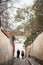 Shapes of people walking in Novy Svet Street, an empty cobblestone medieval