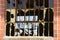 Shards of glass hang from the frame of an old, rusted window in an abandoned warehouse.