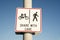 Share with care warning sign on a shared path for pedestrians and cyclists against a clear blue sky background