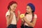 Share sweet donut. Girls in beret hats hold glazed donut red background. Kids playful girls ready eat donut. Friendship