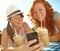 Sharing a funny text. Two adolescent girls enjoying smoothies while texting on a cellphone.