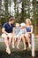 Sharing precious family moments. Cute young family laughing together while sitting on a lakeside jetty - outdoors.