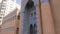Sharjah, UAE - January 13, 2018: Towers of mosque Masjid Al-Zahra. People walking near islamic mosque in Sharjah, United