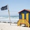 Shark lookout post flag and beach huts South Africa