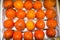 Sharon persimmon in a box stacked in rows of bright orange color. Fruits vegetables berries useful products