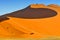 Sharp border of light and shadow over the crest of the dune at sunrise at Sossusvlei Namib Desert, Namib Naukluft National Park of