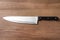 Sharp chef`s knife on wooden table