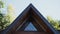 Sharp corner of roof of wooden house, close-up. View of the window attic.