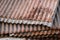 Sharp edges of the rusty metal sheets placed on the floor. Old aged weathered rusty galvanized corrugated iron sheet roof of