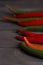 The sharp end of red chili pepper, tails of caen pepper on a dark wooden background