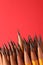 Sharp graphite pencils on red background, space for text