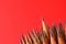 Sharp graphite pencils on red background, space for text