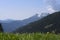 Sharp grass meadow in front and unsharp mountains