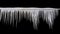 Sharp icicles hanging on the edge of the roof. Melting snow forms icicle