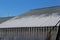 Sharp icicles and melted snow hanging from the eaves of the roof. Beautiful transparent icicles slowly gliding of a roof