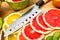 Sharp kitchen knife on cutting Board next to sliced grapefruit a