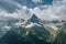 Sharp mountain peak landscape with cloudy sky, rocky ranges and peaks with glaciers and snow fields. Belalakaya, Dombay