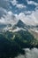 Sharp mountain peak landscape with cloudy sky, rocky ranges and peaks with glaciers and snow fields. Belalakaya, Dombay