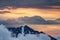 Sharp ridges of Slovenian Alps rise above orange sea of clouds