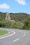 sharp road curve in front of ruin tower of Coraidelstein