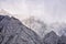 Sharp rocky mountain peaks lurk in the clouds